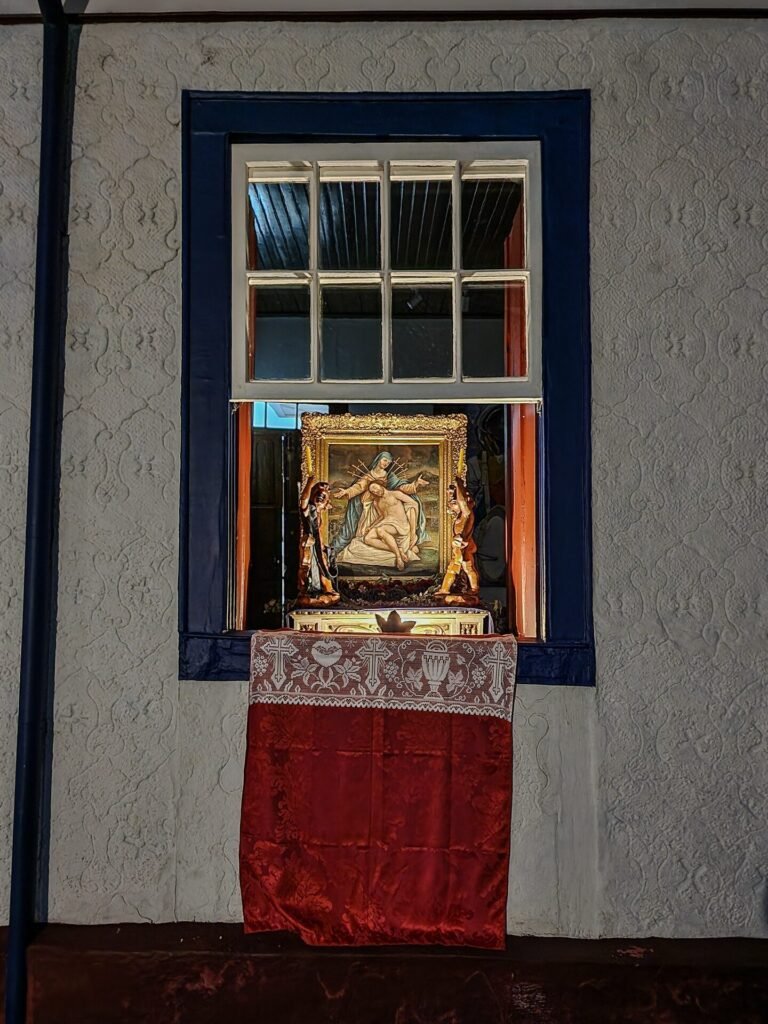 Janela colonial com moldura vermelha e veneziana verde em fachada branca