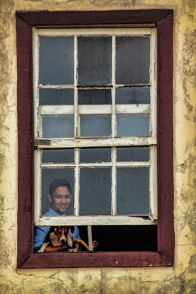Janela colonial com moldura vermelha e veneziana verde em fachada branca