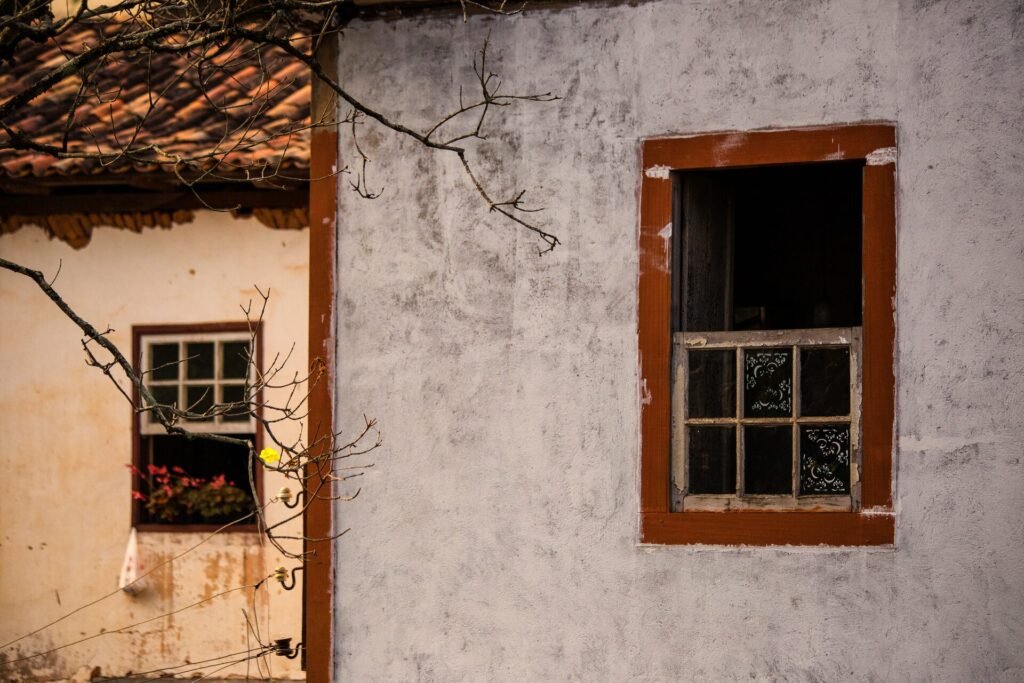 Janela colonial com moldura vermelha e veneziana verde em fachada branca